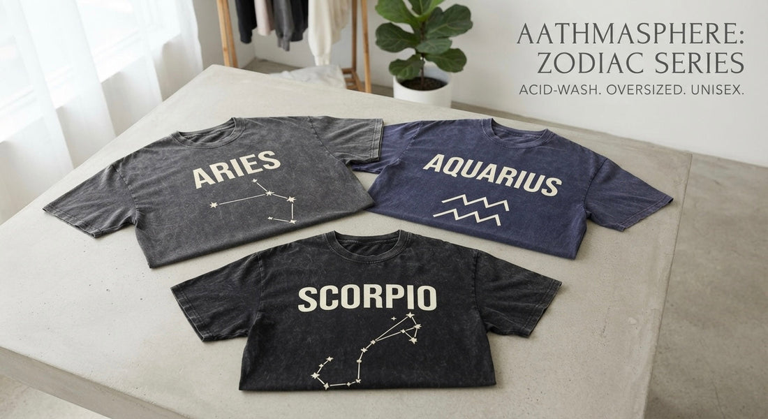 Aathmasphere Zodiac Series acid-washed oversized unisex t-shirts featuring Aries, Aquarius, and Scorpio constellation designs laid out on a minimalist concrete studio surface.